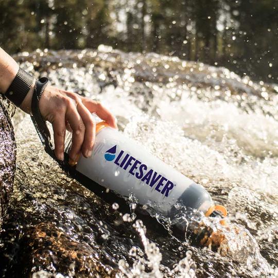 Load image into Gallery viewer, LifeSaver water purifier bottle being used to filter moving river water