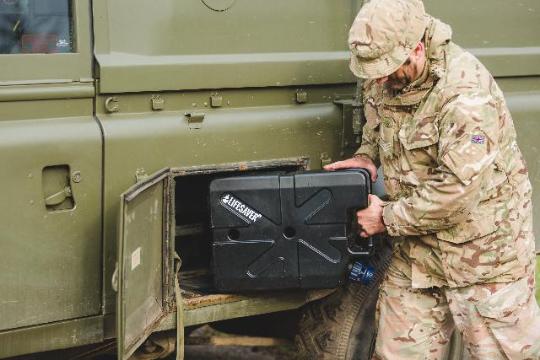 Loading a black jerrycan onto an army vehicle