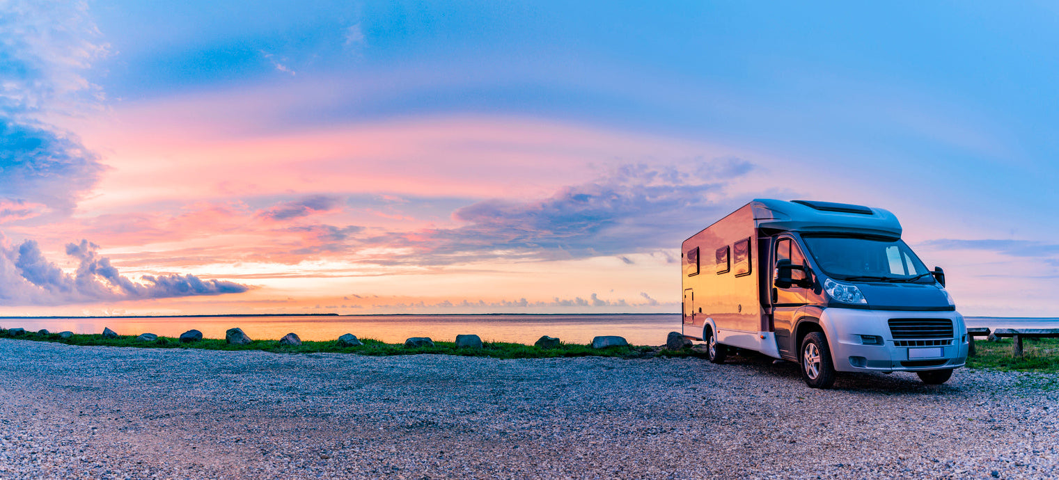 An RV settled for the night by a lake