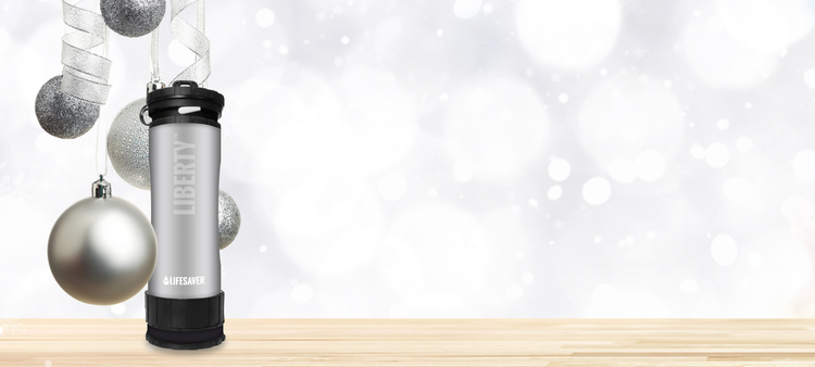 Silver Liberty on a wooden surface with Christmas ornaments and a white blurred background